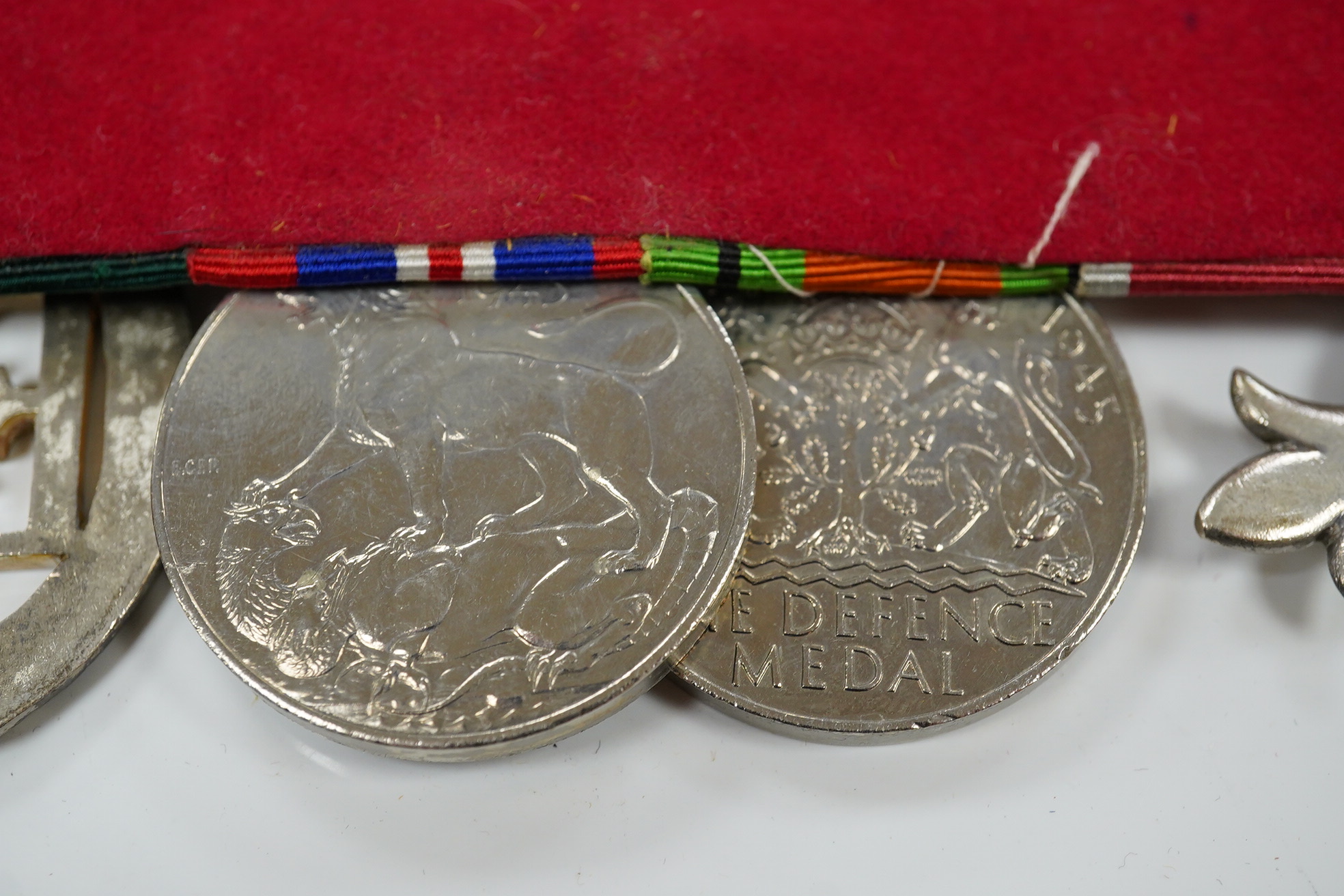 A group of 4 medals including MBE in display case